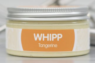 A jar of Tangerine Whipp on light metallic background