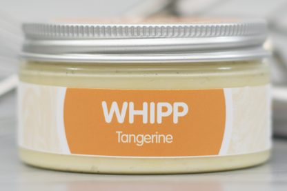 A jar of Tangerine Whipp on light metallic background